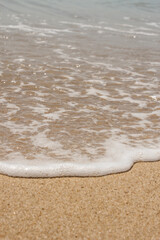 Soft wave of the sea on the sandy beach. Selective focus.