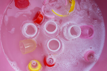 Obraz na płótnie Canvas Wash baby bottles in plastic pink basin