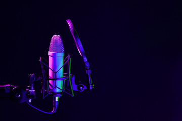 Fototapeta na wymiar Professional microphone against black background in studio