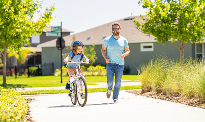 father and son navigate the winding paths together at fatherhood. father and son promenade. father and son in fatherhood. fatherhood of father and son cycling at sunlit park. Cycling duo
