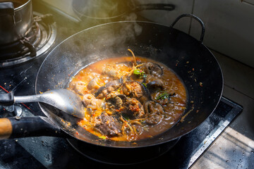 Cooking Home cook style Thai food menu. Catfish curry in a pan on gas stove in the kitchen.