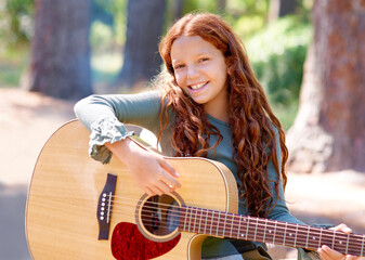 Camp, portrait and girl child with guitar for entertainment, talent or music in woods or forest. Nature, musician and kid with acoustic string instrument outdoor in park or field on weekend trip.