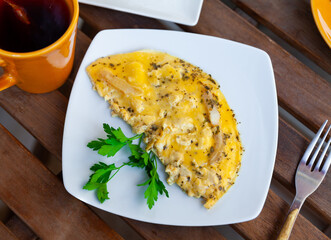 National French dish, omelet made from lightly beaten eggs with milk and herbs on plate