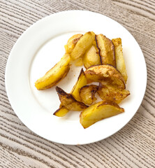 Fried potatoes in a white plate on the table