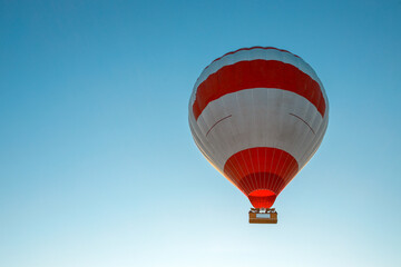 Fototapeta premium Hot air balloon flying against the blue cloudless sky