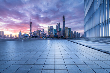Fototapeta na wymiar Empty square floor and glass wall with modern buildings scenery at sunrise in Shanghai