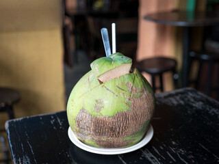 Coconut fruit water drink, on a table in a cafe.