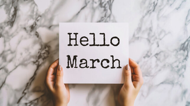Hello March text on white card in female handsle background.
