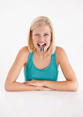 Crazy, woman and portrait of eating fish, tail or strange food in mouth on white background of...