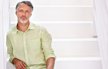 Portrait, mature man and positive on stairs in confidence in career and mockup in studio. Person, happy face and senior entrepreneur with relax in start up company and enterprise by white staircase