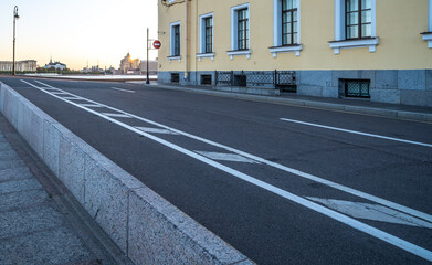 An asphalt road with markings in the city during the day.
