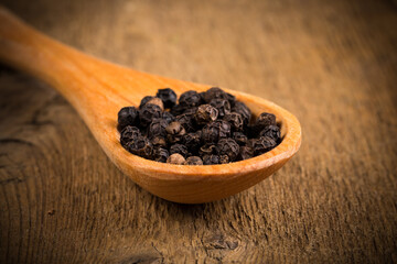 black pepper on wooden spoon