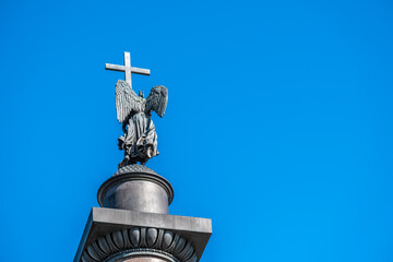 An angel with a cross at the top of a granite column.