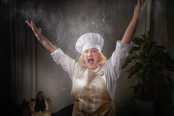 A fat funny female cook in a hat and apron posing and taking selfie in the kitchen with flour....