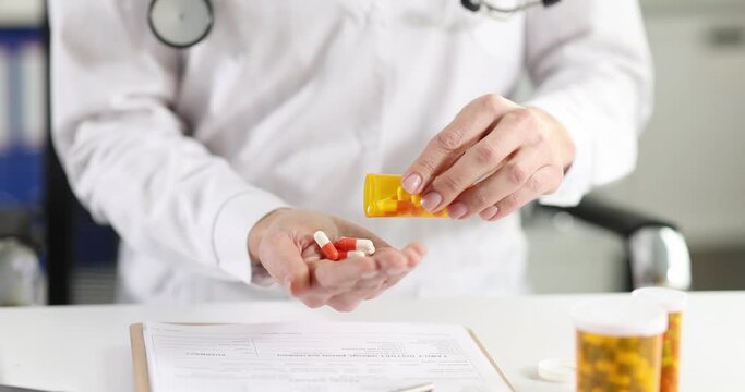 Doctor pouring many capsules of medicine from jar into his hand 4k movie slow motion. Treatment with dietary supplements concept