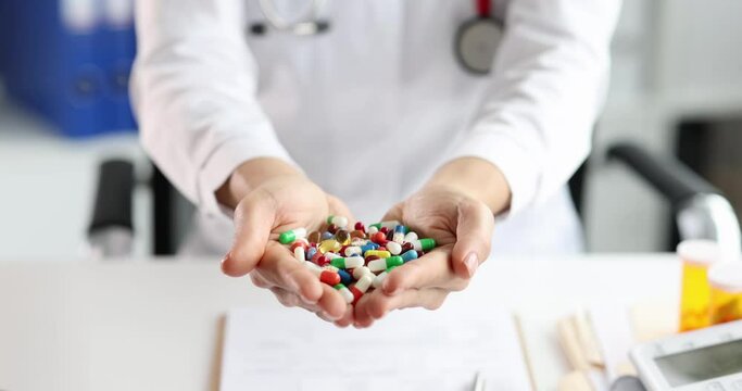 Doctor woman holding handful of multicolored capsules with medicines in clinic 4k movie slow motion. Polypharmacy concept