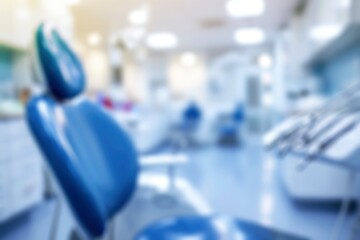 Defocused view of a dental clinic with a blue dental chair in the foreground. Blurred dental background