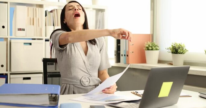 Businesswoman works with documents in office and sneezes.