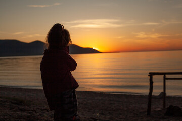 Sneakers on aA girl admiring the sunset. The last rays of the afternoon sun going behind the...