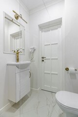 Fototapeta na wymiar White marble bathroom, gold faucets and shower.