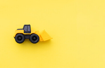 Wheel loader miniature isolated on yellow background. After some edits.