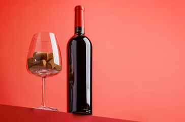 Red wine elegance: Wine glass and bottle against vibrant red background