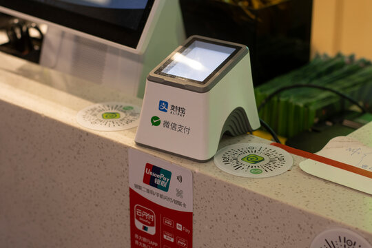 Beijing, China - July 18, 2023: QR code scanner for Alipay and WeChat Pay electronic payments are seen on the cashier counter at a restaurant in Beijing, China.