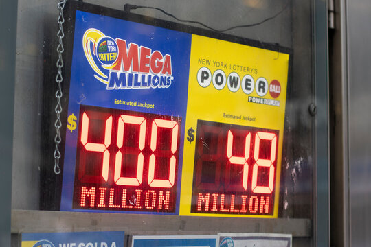 New York, NY, USA - July 8, 2022: Closeup of a storefront screen that shows the estimated jackpots of New York Lottery's Mega Millions and Powerball. America's two big jackpot games concept.