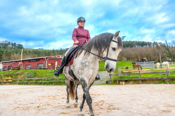 Happy girl with helmet riding a horse