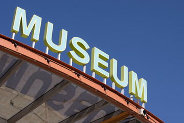 MUSEUM sign isolated against clear blue sky background.