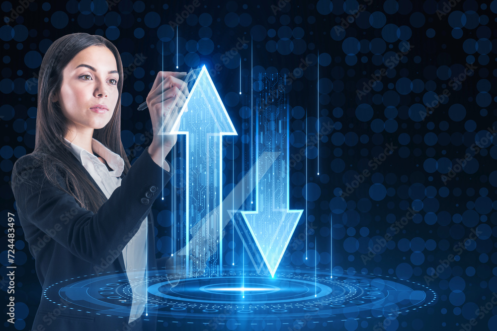 Poster Attractive young european businesswoman using abstract up and down arrows hologram on dark blue background. The concept of digital traffic or exchange. Blue arrow technology background.