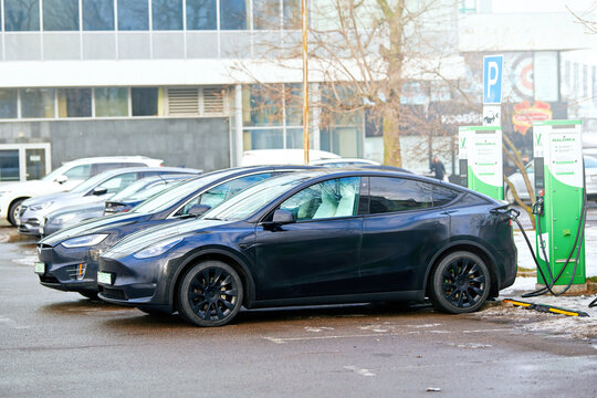 Minsk, Belarus. Jan 28. 2024. Tesla Model X charging battery at free charging station, EV SUV charging battery. Tessla crossover charge battery in winter season at public purking lot