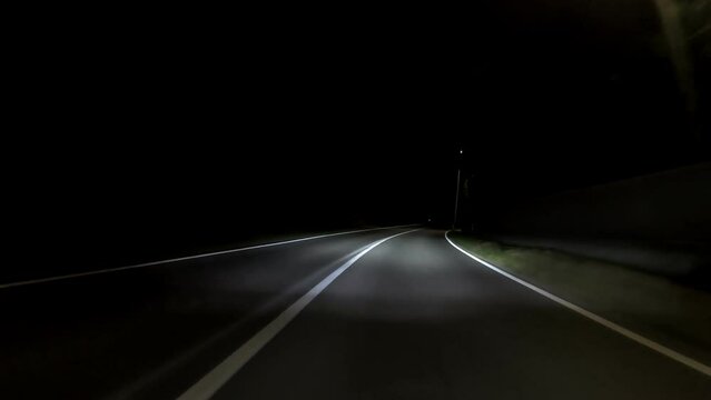 driving a car on countryside road at night with adaptive matrix headlights