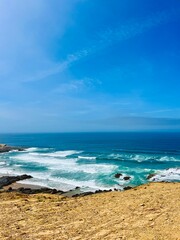 Rocky ocean coast, ocean bay with rocky coast and sand beach, blue sky, no people