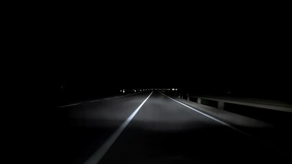 driving a car on countryside road at night with adaptive matrix headlights