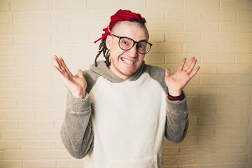 A young funny hipster with glasses and red dreadlocks
