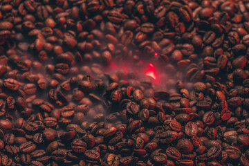 Roasted coffee beans with smoke and fire background. Close up,