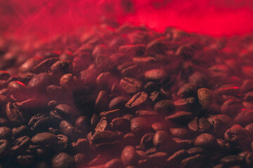 Roasted coffee beans with smoke and fire background. Close up,