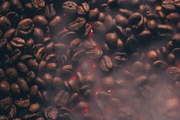 Roasted coffee beans with smoke and fire background. Close up,