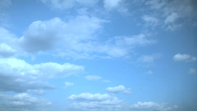 Slow moving white clouds in a blue summer sky. Soothing unhurried background as a substrate for titles.