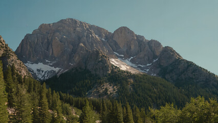 a mountain range with a few trees in the foreground and a blue sky