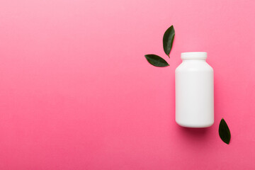 supplement pills with medicine bottle health care and medical top view. Vitamin tablets. Top view mockup bottle for pills and vitamins with green leaves, natural organic bio supplement, copy space