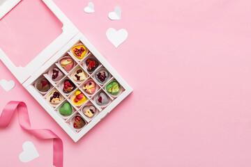 Valentine day composition: sweet candy, with gift boxes with bow and red felt hearts, photo template, background. Top View with copy space