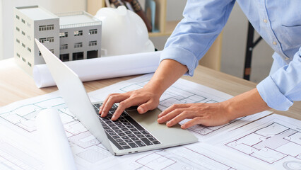 Engineer and construction concept. Engineer technician using laptop to drawing design building...