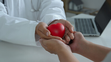 Doctor's hand gives a red heart to a man. Love and healthcare concepts, Red heart in hands, Doctor...