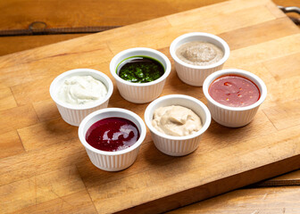 Assorted sauces on a wooden board