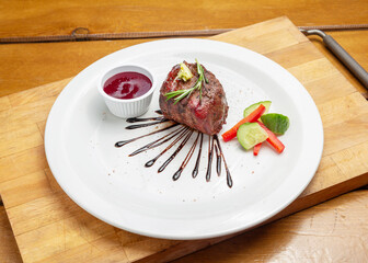 Filet mignon on a plate on a wooden board