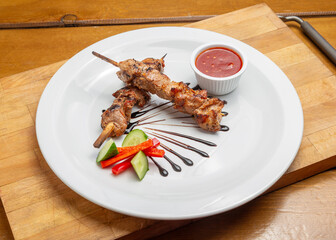 Pork kebab on a plate on a wooden board