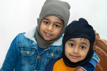 Two brothers are looking at the camera while dressed in winter clothes. Two brothers bound by love and a strong bond.