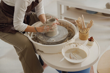 Close up of artisan's hands shaping clay bowl in pottery studio. Pottery art and creativity